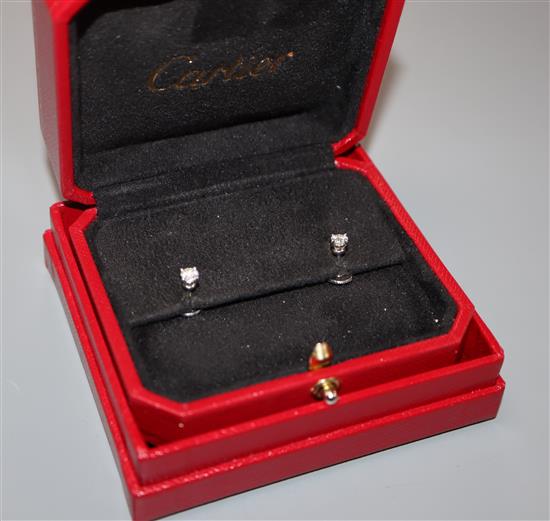 A pair of Cartier platinum set solitaire diamond ear studs, with Cartier box.